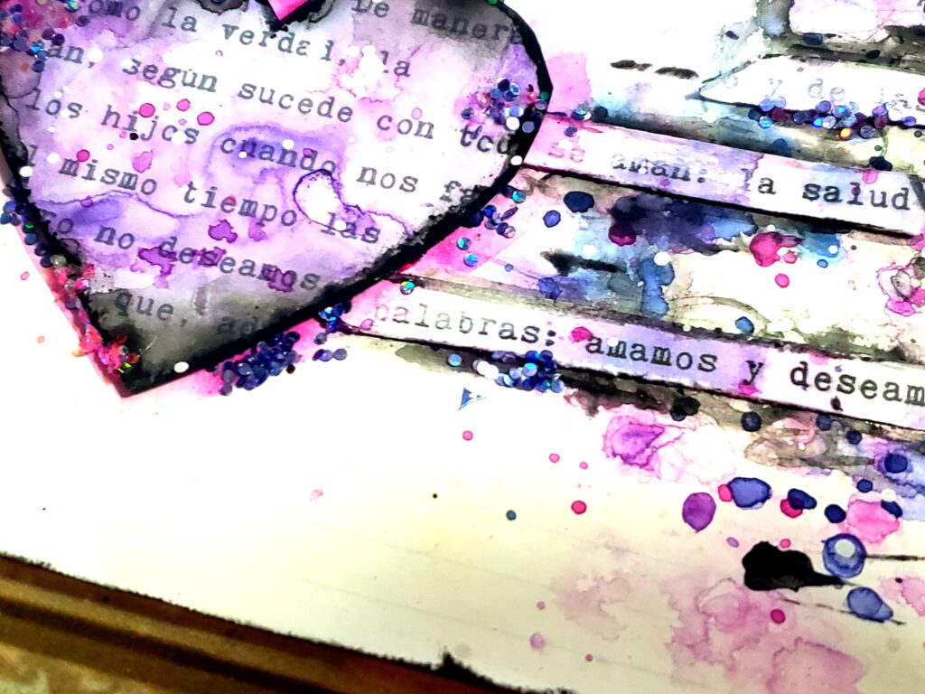 En la imagen se vé una hoja de Art Journal de composición horizontal doble triangulo con forma de moño, donde el centro está ocupado con un corazón violeta y enmarcado en negro, se ven brillos de glitter y palabras que aluden a los hijos. 